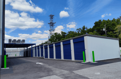 Row of outdoor drive-up storage units with navy blue doors